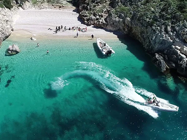 Visitantes nadando en el agua turquesa de la bahía de Dafina