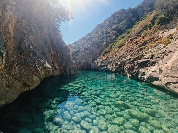 Agua clara y entrada rocosa en la Bahía del Inglés cerca de Vlore