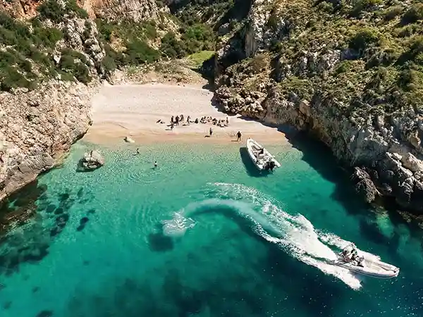 Lancha rápida llegando a la bahía de Bristan, con agua turquesa, durante un tour en barco en Vlora