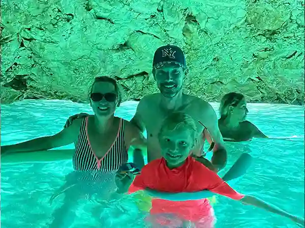 Familia nadando en aguas turquesas dentro de la Cueva Azul en Vlora, Albania